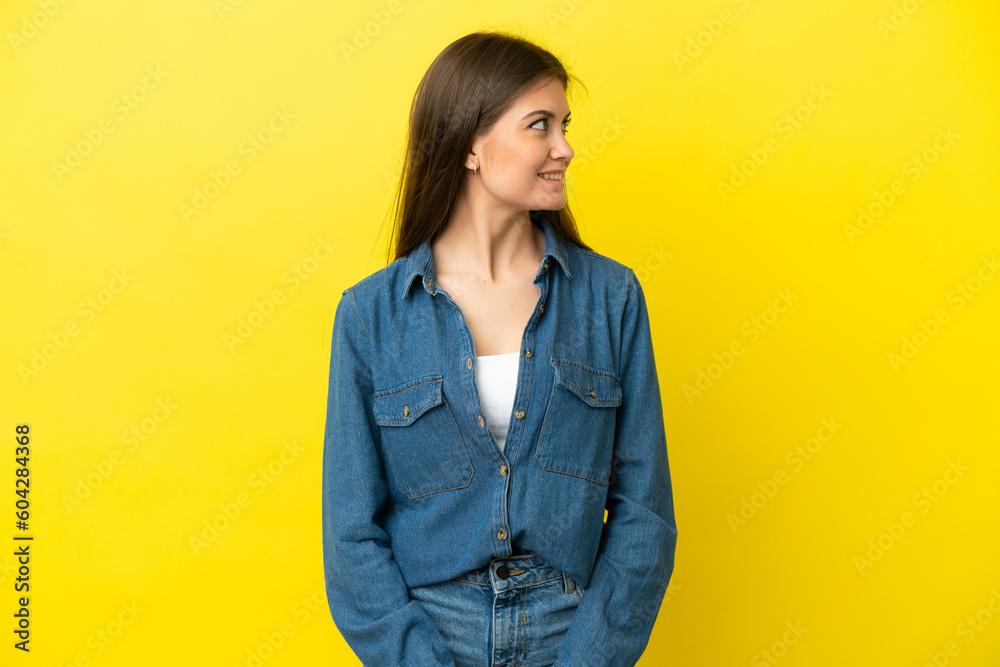 Young caucasian woman isolated on yellow background looking side Young caucasian woman isolated on yellow background looking side