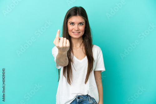 Young caucasian woman isolated on blue background doing coming gesture