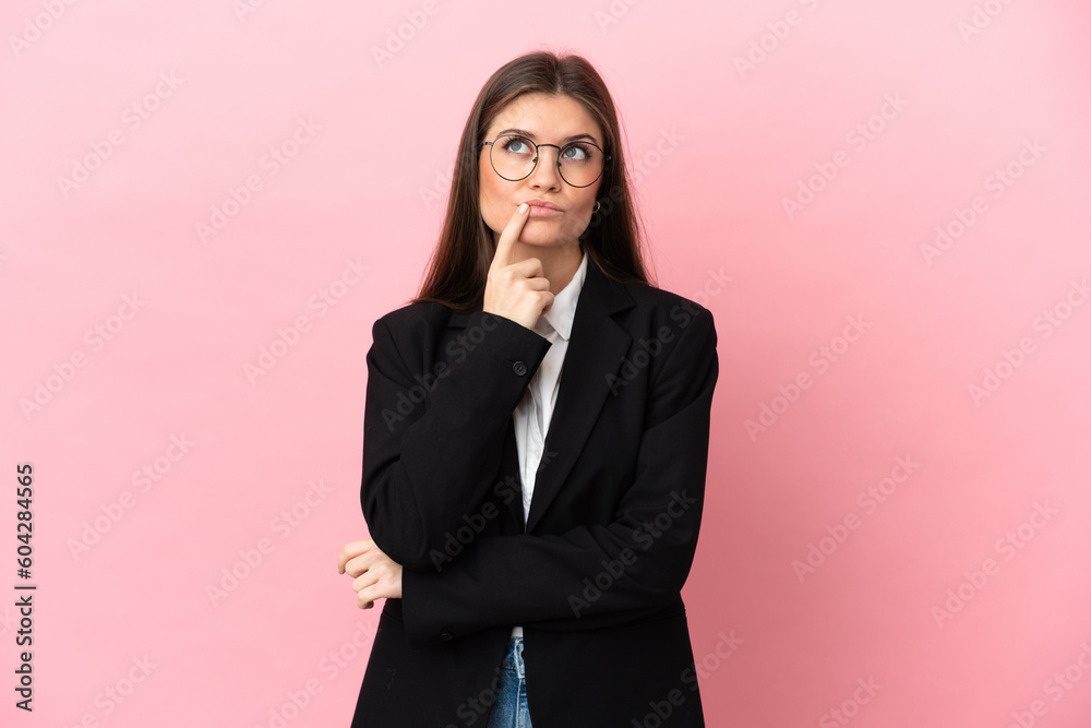Young Business caucasian woman isolated on pink background having doubts while looking up Young Business caucasian woman isolated on pink background having doubts while looking up