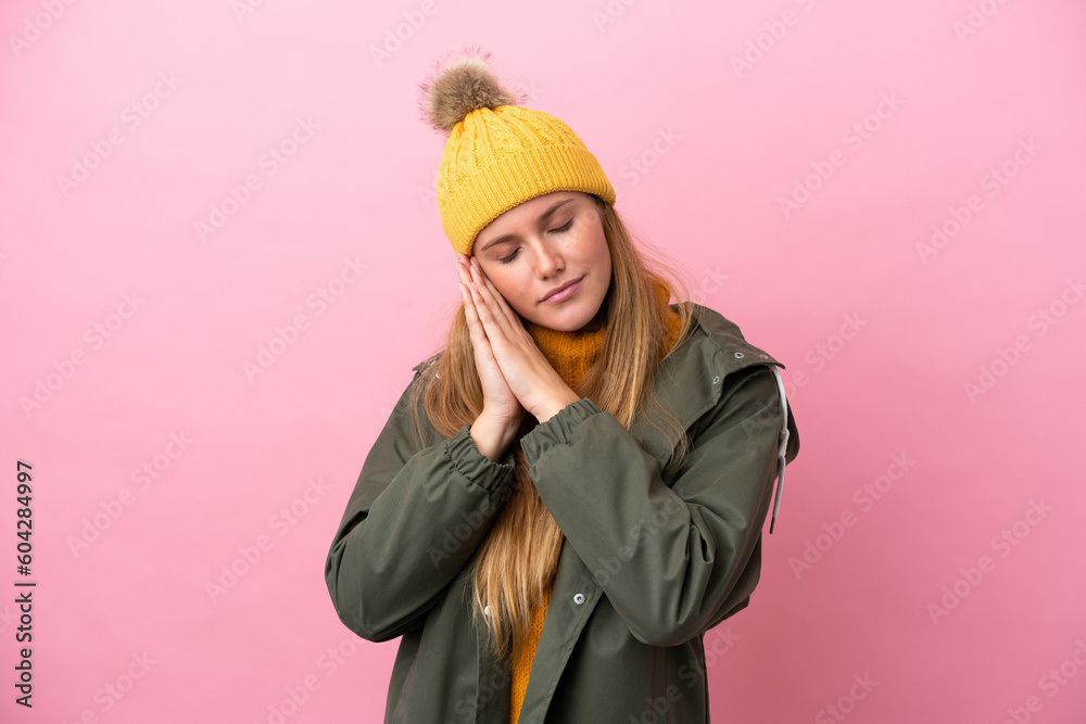 Young blonde woman wearing winter jacket isolated on pink background making sleep gesture in dorable expression Young blonde woman wearing winter jacket isolated on pink background making sleep gesture in dorable expression