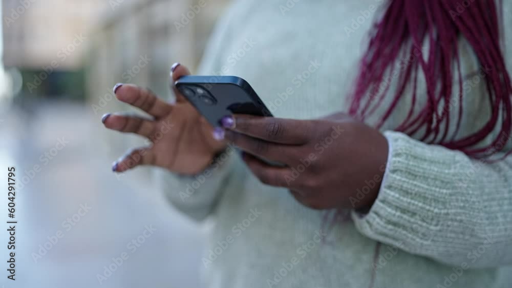 African woman with braided hair using smartphone at street African woman with braided hair using smartphone at street