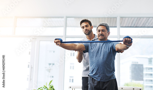 Physiotherapy, help and band with old man and doctor for training, rehabilitation and injury. Medical, healing and healthcare with physiotherapist and patient for consulting, stretching and fitness photo