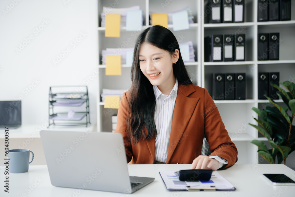 Young beautiful woman typing on tablet and laptop while sitting at the working wooden table office. Young beautiful woman typing on tablet and laptop while sitting at the working wooden table office.