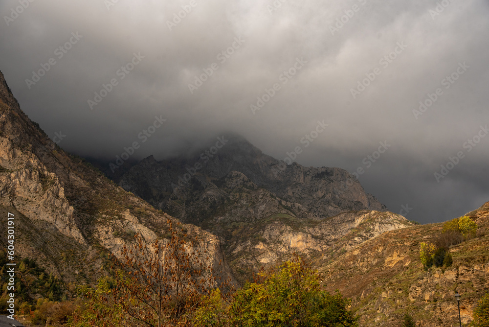 Panoramic view of a typical mountain landscape of northern Spain, nature view with a big rocky mountain in the middle surrounded by lots of vegetation on a cloudy day in Huesca