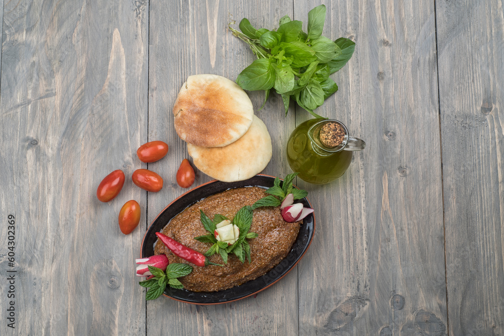 Traditional Lebanese Raw meat kibbeh with olives oil and pita bread and