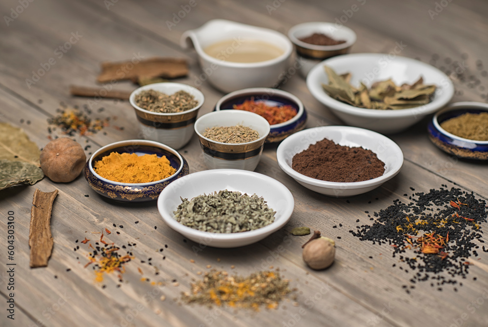 large collection of different spices and herbs on a wooden table large collection of different spices and herbs on a wooden table