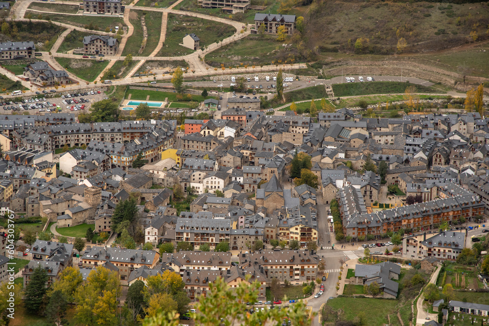 Panoramic and aerial view of the tourist village of Huesca, Benasque, made up of small brick houses with slate roofs typical of high mountain architecture, on a cloudy day. Panoramic and aerial view of the tourist village of Huesca, Benasque, made up of small brick houses with slate roofs typical of high mountain architecture, on a cloudy day.