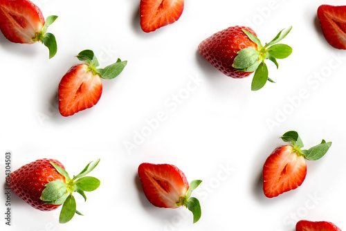 Fototapeta Naklejka Na Ścianę i Meble -  Strawberries on a white background. Pattern of whole berries and halves in random order. Composition in the style of flat lay.
