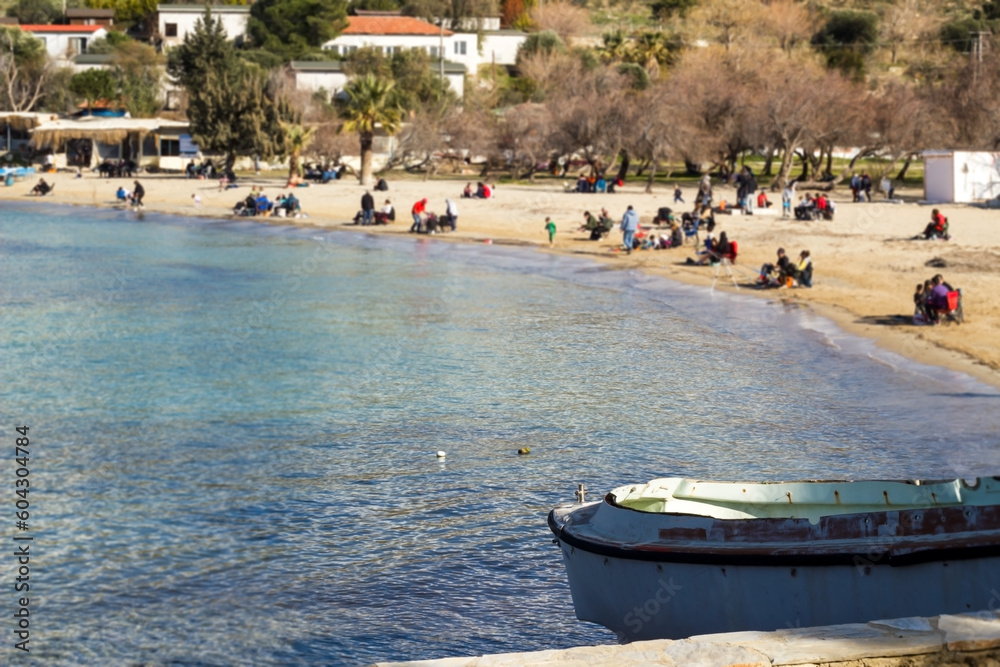 Obraz premium Blurred people at Akkum Beach in Seferihisar, Izmir, Türkiye, enjoying the sun in February