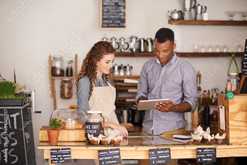 Tablet, restaurant and owner in teamwork of people, discussion and manage orders in store. Waiters, black man and happy woman in cafe with technology for inventory, stock check and managing sales.