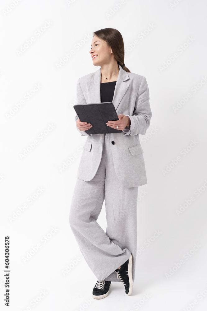 Young caucasian businesswoman formal wear, holding digital tablet, standing over white background. Full length portrait Young caucasian businesswoman formal wear, holding digital tablet, standing over white background. Full length portrait