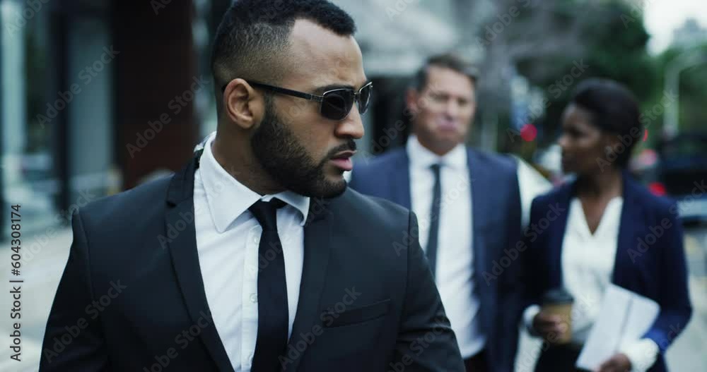 Bodyguard, business team walking in the city streets together with bodyguard black suits. Safety or safe keeping, authority and serious people walk downtown or urban road for protection or defence Bodyguard, business team walking in the city streets together with bodyguard black suits. Safety or safe keeping, authority and serious people walk downtown or urban road for protection or defence