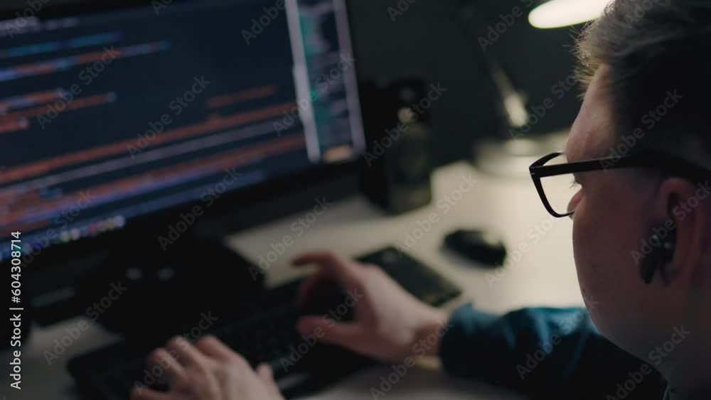 A young middle-aged programmer works remotely in his city apartment at night. IT specialist sits in front of the monitor of his laptop computer. Web programming writing website code, working remotely
A young middle-aged programmer works remotely in his city apartment at night. IT specialist sits in front of the monitor of his laptop computer. Web programming writing website code, working remotely