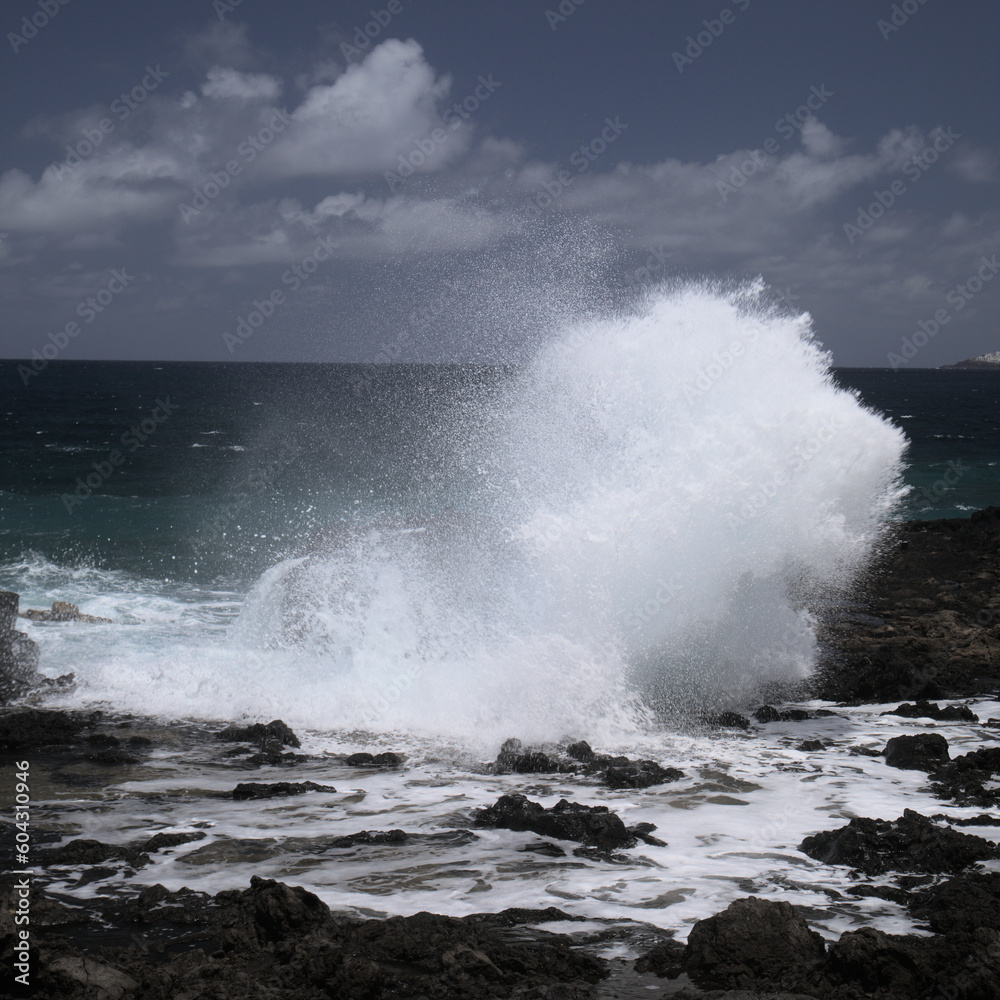 Gran Canaria, north west coast around natural swimming pools Salinas de Agaete, 
waves breaking against old eroded dark lava platform