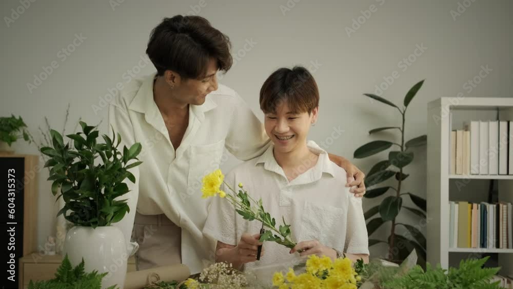 Happy moment of young asian gay couple talking to etch other, arranging flowers at home. Love, romance and relationships Happy moment of young asian gay couple talking to etch other, arranging flowers at home. Love, romance and relationships