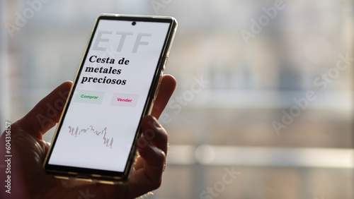 An investor analyzing an etf fund. ETF text in Spanish : precious metals basket, buy, sell.