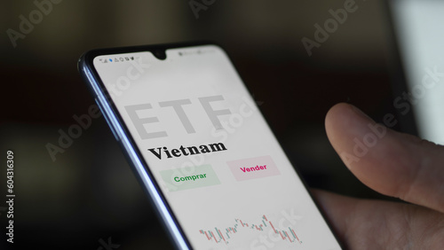 An investor analyzing an etf fund. ETF text in Spanish : Vietnam, buy, sell.