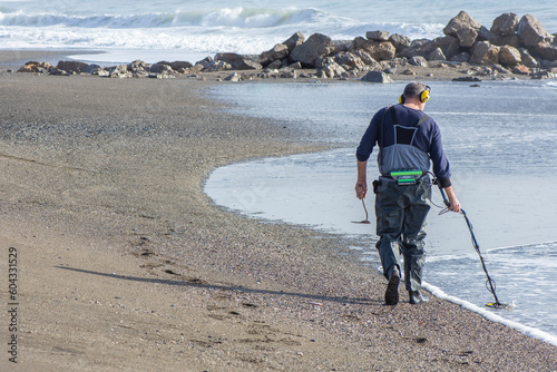man with a metal detector on the beach