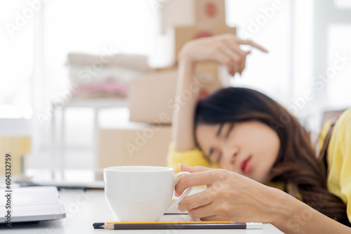 Overworked businesswoman at home office exhaust holding cup of coffee hand trying to find solution for given problem working too hard need break for better concentration