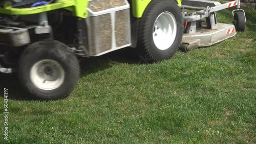 4K view of the lawn mower machine mows the grass on the lawn.