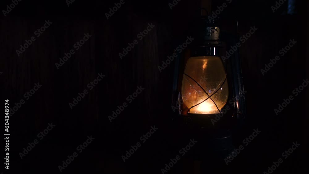 Lit hurricane warm reflected light lamp standing in a dark room. Kerosene lamp Close up views 4k video.