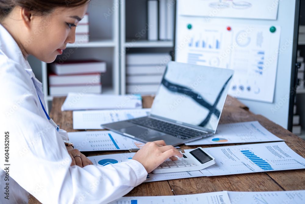 Obraz premium Accountant using calculator and writing on paper, Business woman working audit calculating price taxes loan rates, bookkeeper or financial inspector hand making result
