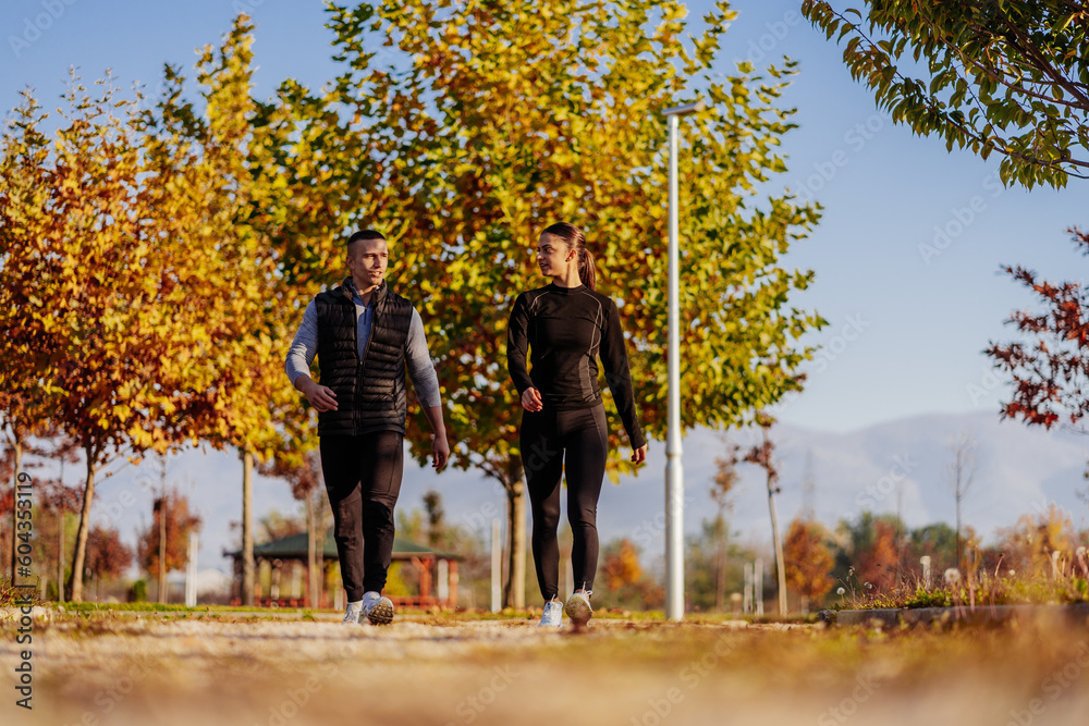 Obraz premium A front view photo of sporty couple hanging out in the park and having a conversation