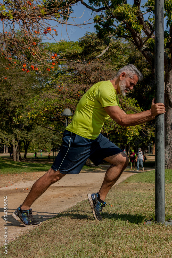 50 year old man jogging in the park on a beautiful sunny day