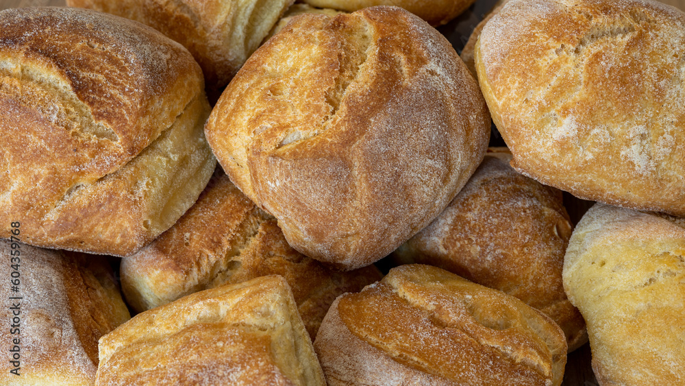 close up of heap of fresh baked bread on wooden background