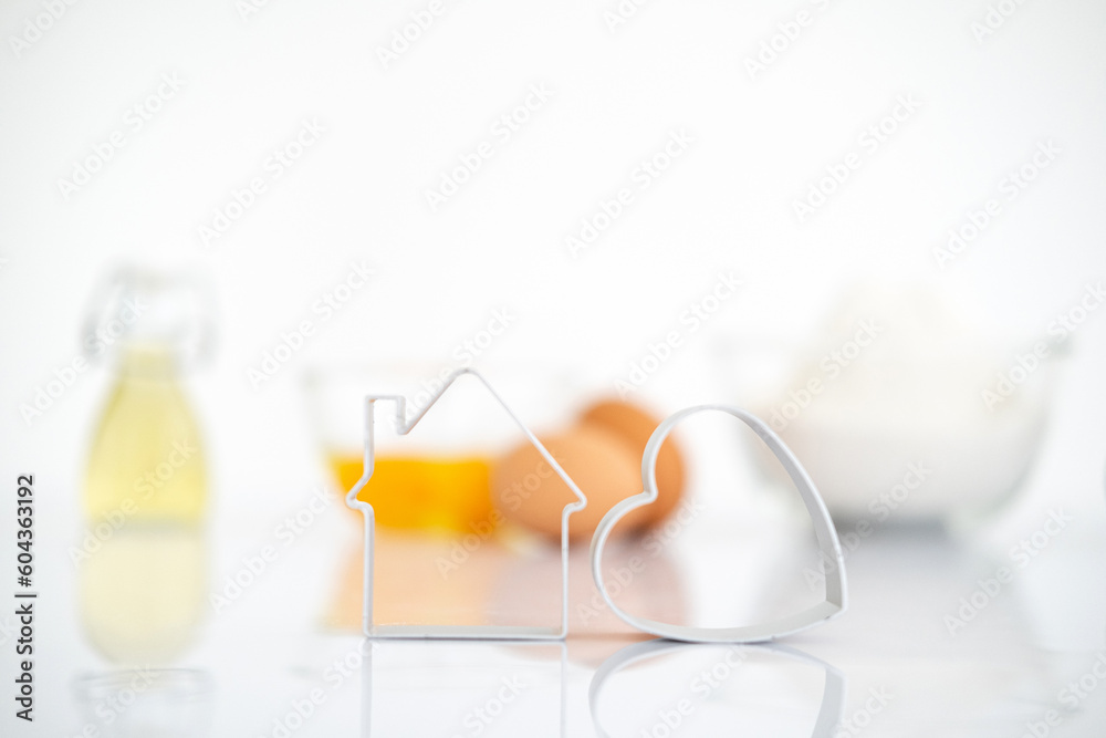 Bakery products.Dessert ingredients on white reflect table background . Front view. Copy space. egg, flour, milk, oil, cookies cutter. Bakery products.Dessert ingredients on white reflect table background . Front view. Copy space. egg, flour, milk, oil, cookies cutter.