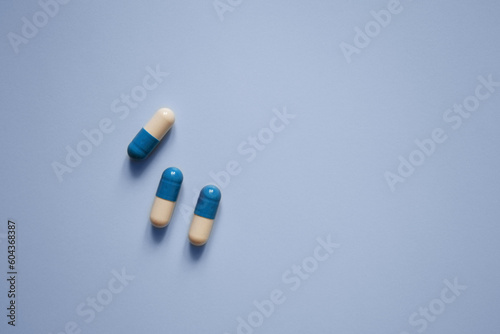 three capsules on a blue background, medication, medical workers day, medical care, banner for the hospital