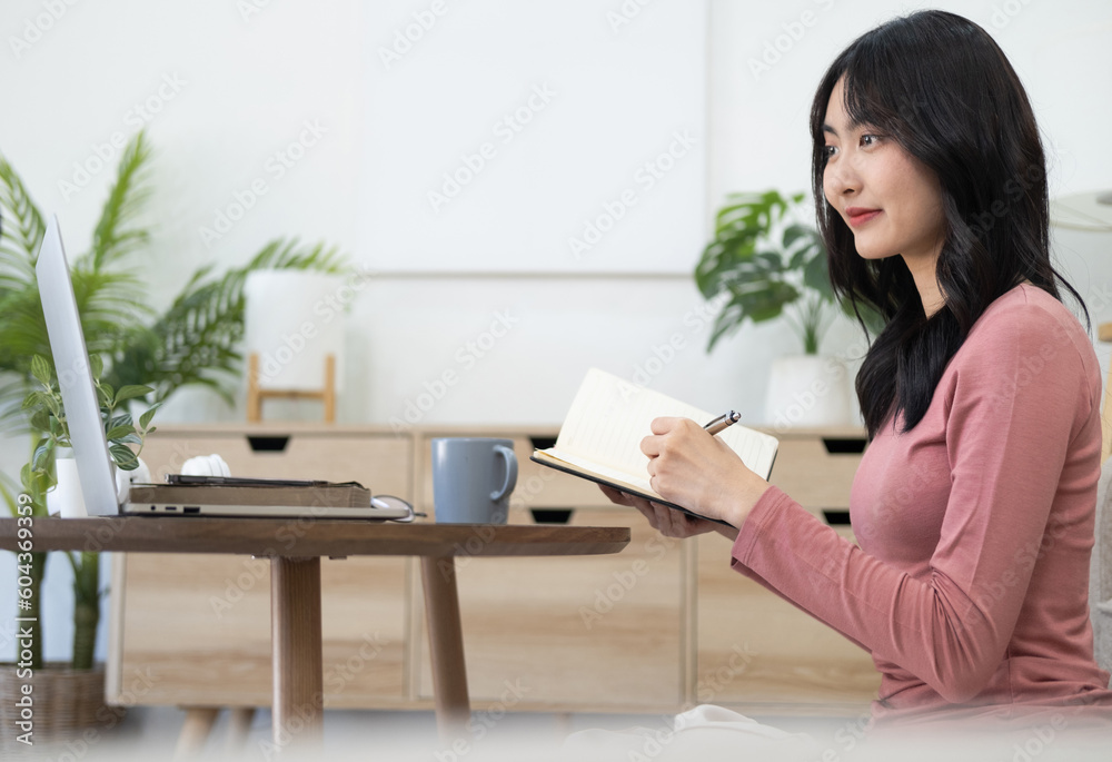 Business planning, E learning concept. Casual business woman writing on notebook and working on laptop computer in modern office. woman studying online course via laptop and lecture on notepad.
