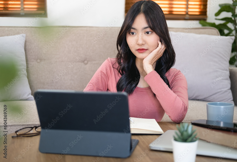 Head shot focused woman taking notes watching webinar, studying online at home, Young female listening to lecture, engaged in internet educational course, remote education , working online. Head shot focused woman taking notes watching webinar, studying online at home, Young female listening to lecture, engaged in internet educational course, remote education , working online.