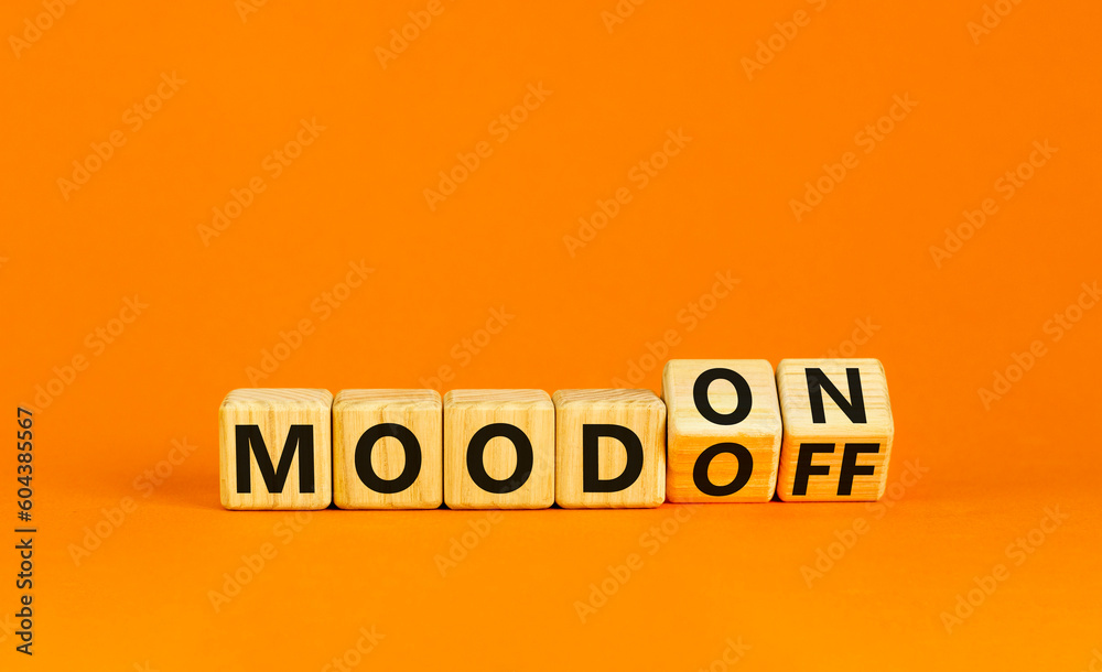 Mood on or off symbol. Businessman turns wooden cubes and changes word Mood off to Mood on. Beautiful orange table orange background. Business and mood on or off concept. Copy space.