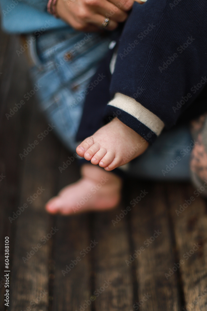 Newborn in mother is arms. Feed the baby. Child is legs. Mom walks with baby