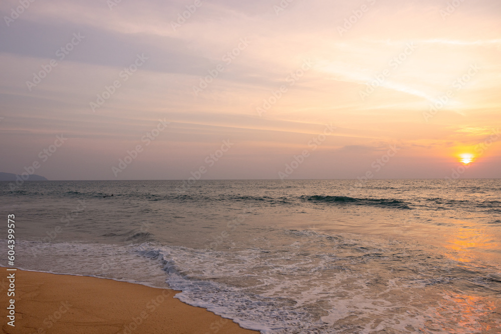 Obraz premium Very nice sunset over the sea at Mai Khao Beach on the island of Phuket in Thailand.