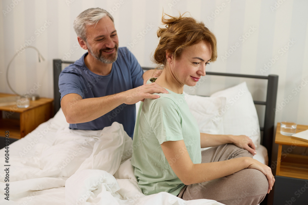 Mature man giving a shoulder massage to his wife at home Mature man giving a shoulder massage to his wife at home