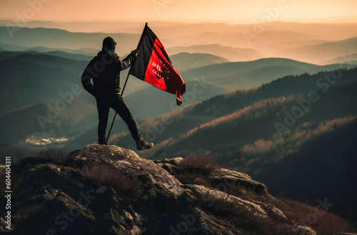 someone is flying a black flag on a mountain
