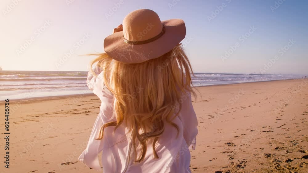 Attractive blond woman at the beach at sunset in Southern California. Slow Motion.