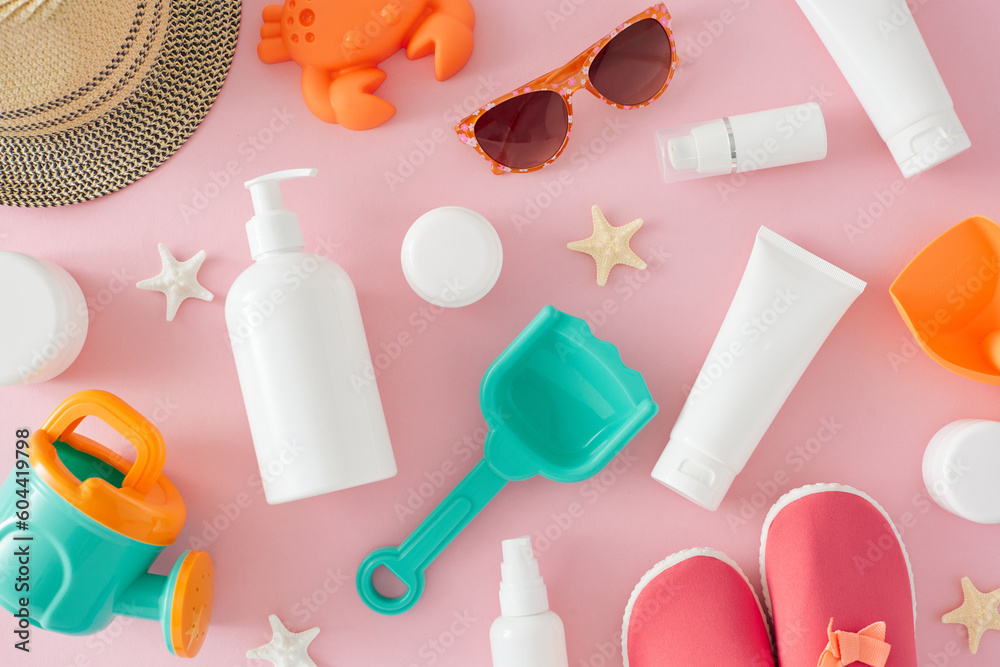 Baby summer skincare concept. Top view flat lay of cosmetic bottles, sunhat, starfish, kids summer accessories, sunglasses and baby beach shoes on light pink background Baby summer skincare concept. Top view flat lay of cosmetic bottles, sunhat, starfish, kids summer accessories, sunglasses and baby beach shoes on light pink background