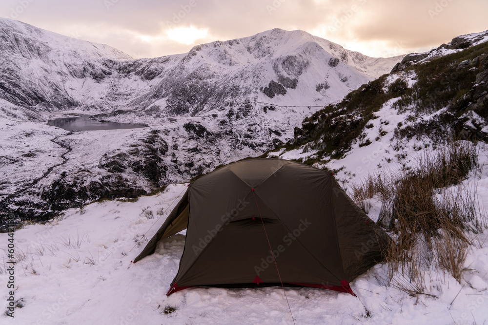 A wild camping tent in the mountains of Snowdonia in Wales UK during winter snow