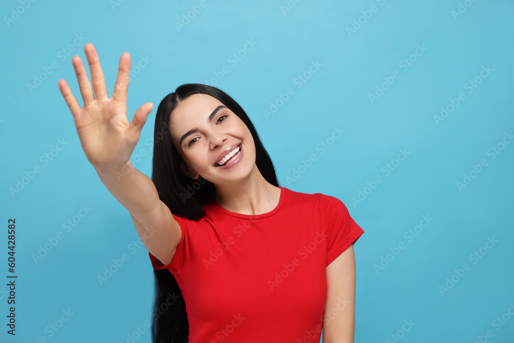 Happy woman giving high five on light blue background. Space for text Happy woman giving high five on light blue background. Space for text