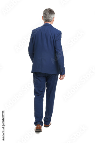 Mature businessman in stylish clothes walking on white background, back view