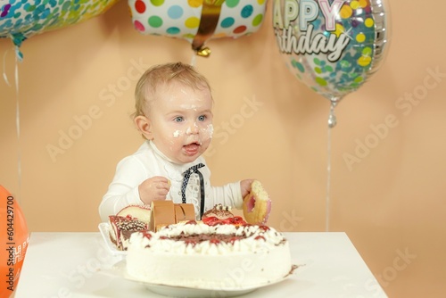 A small child on a holiday is smeared with a face in a cake.