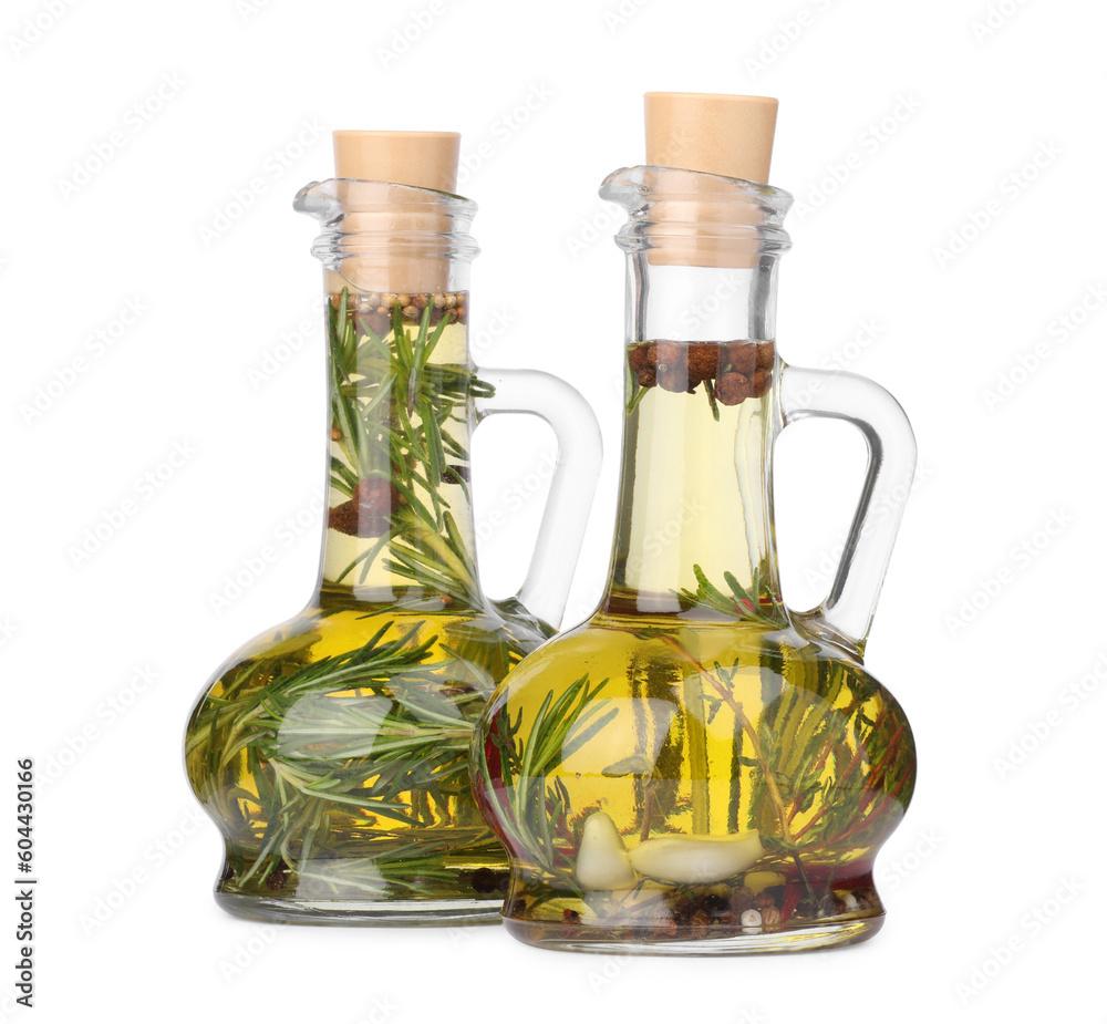 Glass jugs of cooking oils with spices and herbs on white background Glass jugs of cooking oils with spices and herbs on white background