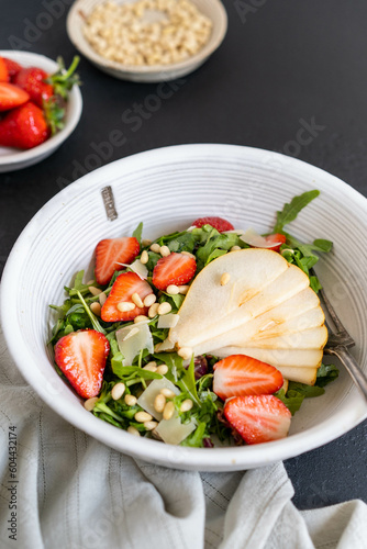 Homemade Italian arugula, pear and strawberry salad with pine nuts. Recipe from the chef. 