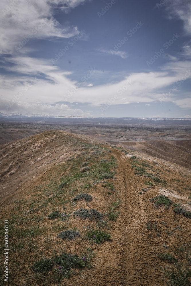Trail on ridgeline of grassy hill in badlands terrain in Montrose Colorado