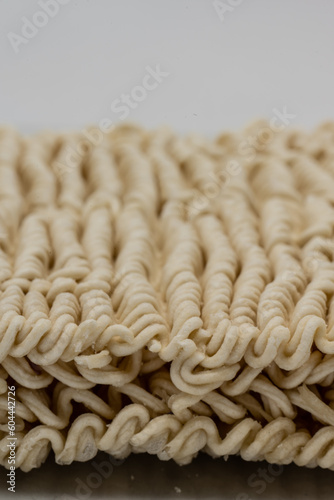 Dry instant ramen noodles on white background.