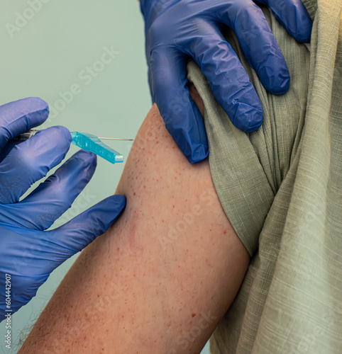 Person getting a Covid vaccine shot in the right shoulder.