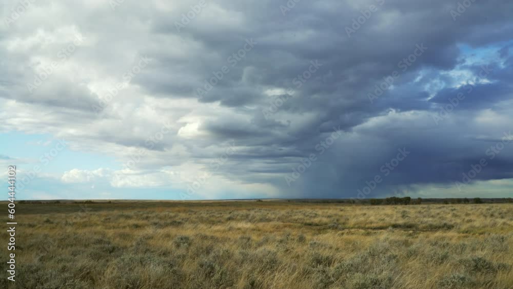 Wind drives rain laden clouds across afternoon fall prairie Wind drives rain laden clouds across afternoon fall prairie